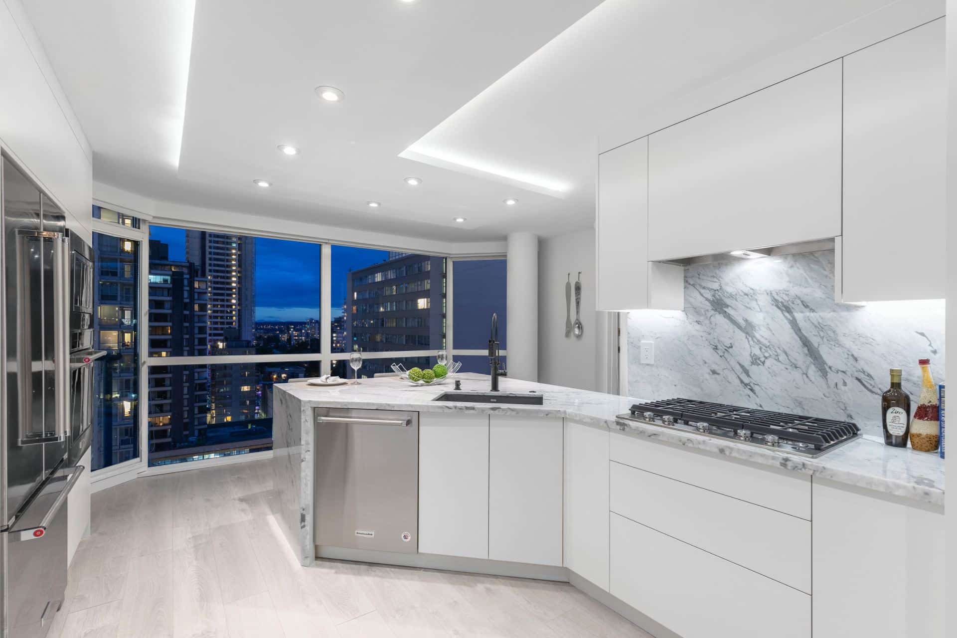 modern-white-kitchen-renovation-vancouver-marble-countertop-black-faucet-sink-custom-ceiling-lighting-dropped