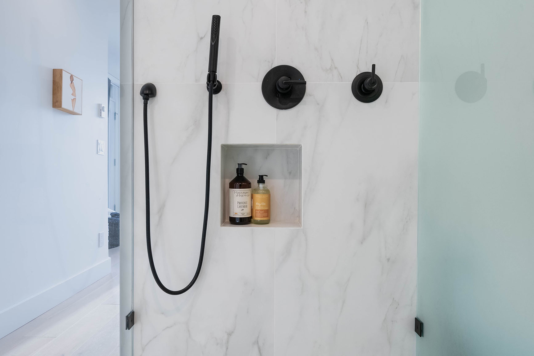 shower-renovation-balck-fixtures-and-white-marble-tiles